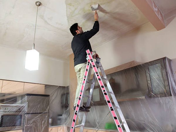 Man working on the ceiling of a kitchen